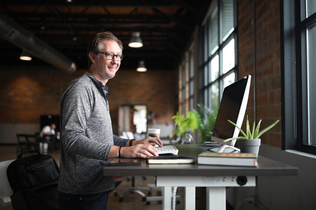 Moderne werkplek met flexibele inrichting, ergonomische meubels, natuurlijk licht en glazen scheidingswanden